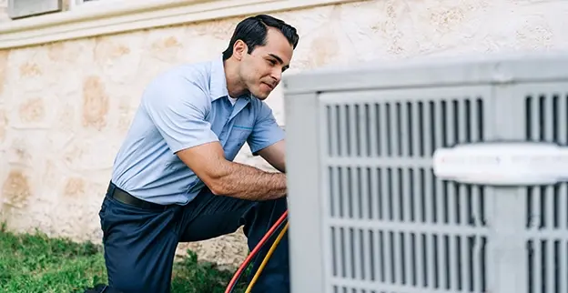 HVAC technician making a quick air conditioner repair on an outdoor unit in Walworth County, WI